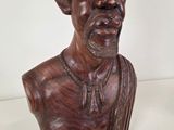 wooden bust of a man with a necklace on his neck