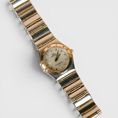 un gros plan d'une montre sur une surface blanche avec un fond blanc