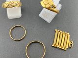 three gold rings, a ring, and a ring with a cross on it