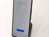 the back of a black phone with a blue button on it