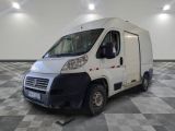 une camionnette blanche garée sur un sol en damier