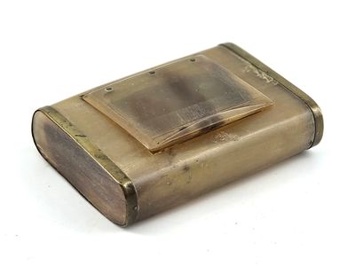 a small brass cigarette case on a white surface
