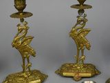 several brass candlesticks and candlestick holders on a table
