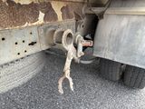 a rusted tire on the side of a truck with a wrench attached to it