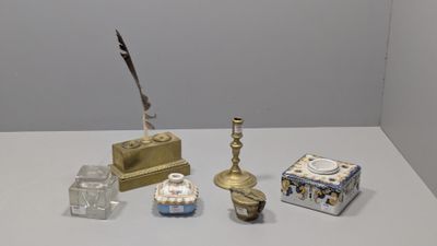 une table blanche sur laquelle se trouvent divers objets, ainsi qu'un stylo et un encrier