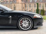a black sports car parked in front of a large building