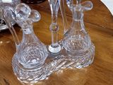 trois vases en verre posés sur une table, avec un vase à l'arrière-plan