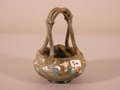 a small vase with a handle that has flowers on it