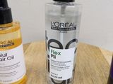 two bottles of hair products sitting on a table next to each other
