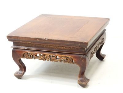 une petite table en bois avec un plateau en bois posé sur un plan de travail blanc