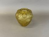a yellow glass vase that is sitting on a white surface