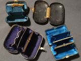four pieces of blue and gold purses are lined up on a table