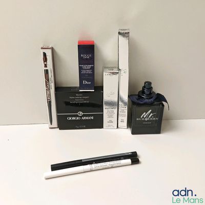 un flacon de liquide, un stylo et une boîte de mascara posés sur une table