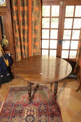 une table sur laquelle se trouve une horloge, dans un coin de la pièce