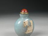 a small blue vase with a red lid sitting on a table