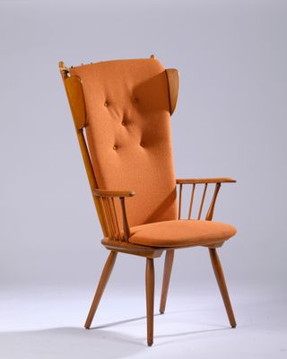 une chaise orange avec une structure en bois et des accoudoirs, sur fond blanc