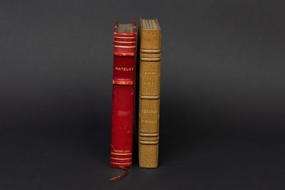 deux vieux livres posés l'un à côté de l'autre sur une surface noire