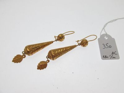 une paire de boucles d'oreilles en or ornées de feuilles, avec des feuilles qui pendent