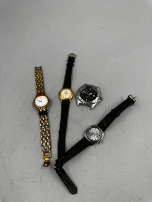 trois montres et une montre posées sur une surface blanche