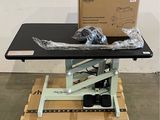 une table noire sur laquelle se trouvent une boîte et une paire de ciseaux