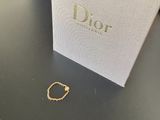 une bague en or est posée sur une table, à côté d'une boîte blanche