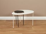 une table blanche sur laquelle est posée une assiette noire
