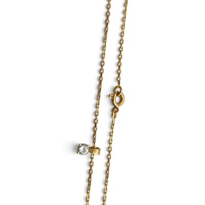 un gros plan d'un collier avec une croix suspendue à une chaîne