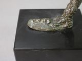a bronze statue of a shoe on a black box