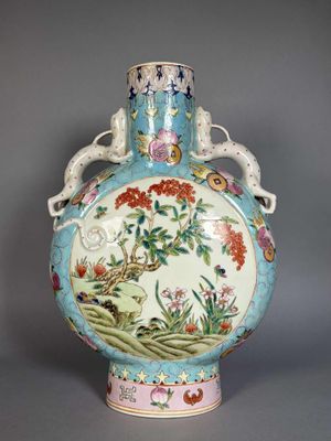 a blue vase with flowers and birds painted on it
