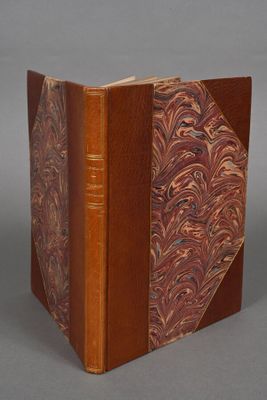 an old book with a brown cover sitting on top of a table