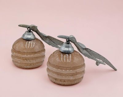 pair of antique salt and pepper shakers on a pink background