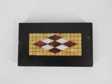 a close up of a black and white tile with a red and yellow design