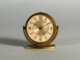 une petite horloge en or posée sur une table