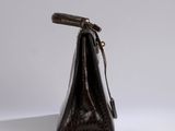 a brown purse with a handle on a white surface