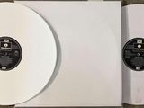 two white vinyl records sitting on top of each other on a table