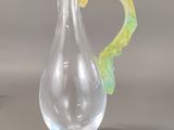 a glass vase with a yellow and green decoration on it