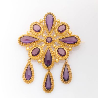 a gold and amethorate broochle with purple stones