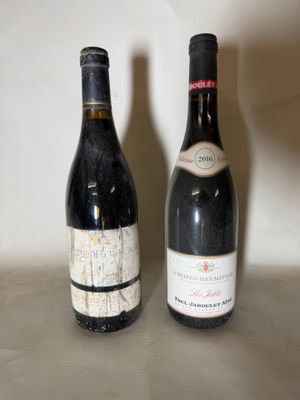 two bottles of wine sitting next to each other on a counter