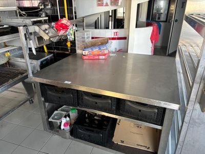 Une table de sortie découpe en inox roulante formant étagère en partie