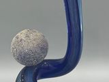 a blue vase with two rocks on top of it