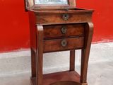 a small wooden table with a mirror on top of it