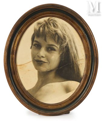 une vieille photo d'une femme aux cheveux longs, dans un cadre en bois