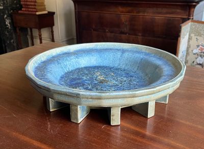 un bol bleu posé sur une table en bois dans un salon
