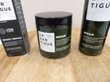 two bottles of hair products sitting on a table next to a box