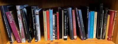 many books that are on a wooden shelf