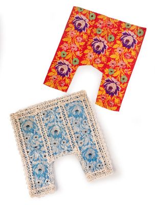 three pieces of cloth and a pair of scissors on a white surface