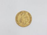 a gold coin on a white surface with a white background