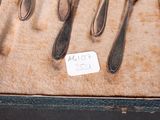 a lot of spoons and forks on display in a box