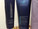 two tubes of hydrating products sitting on a table next to a bag