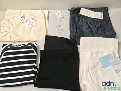 several pairs of pants and shirts are laid out on a table